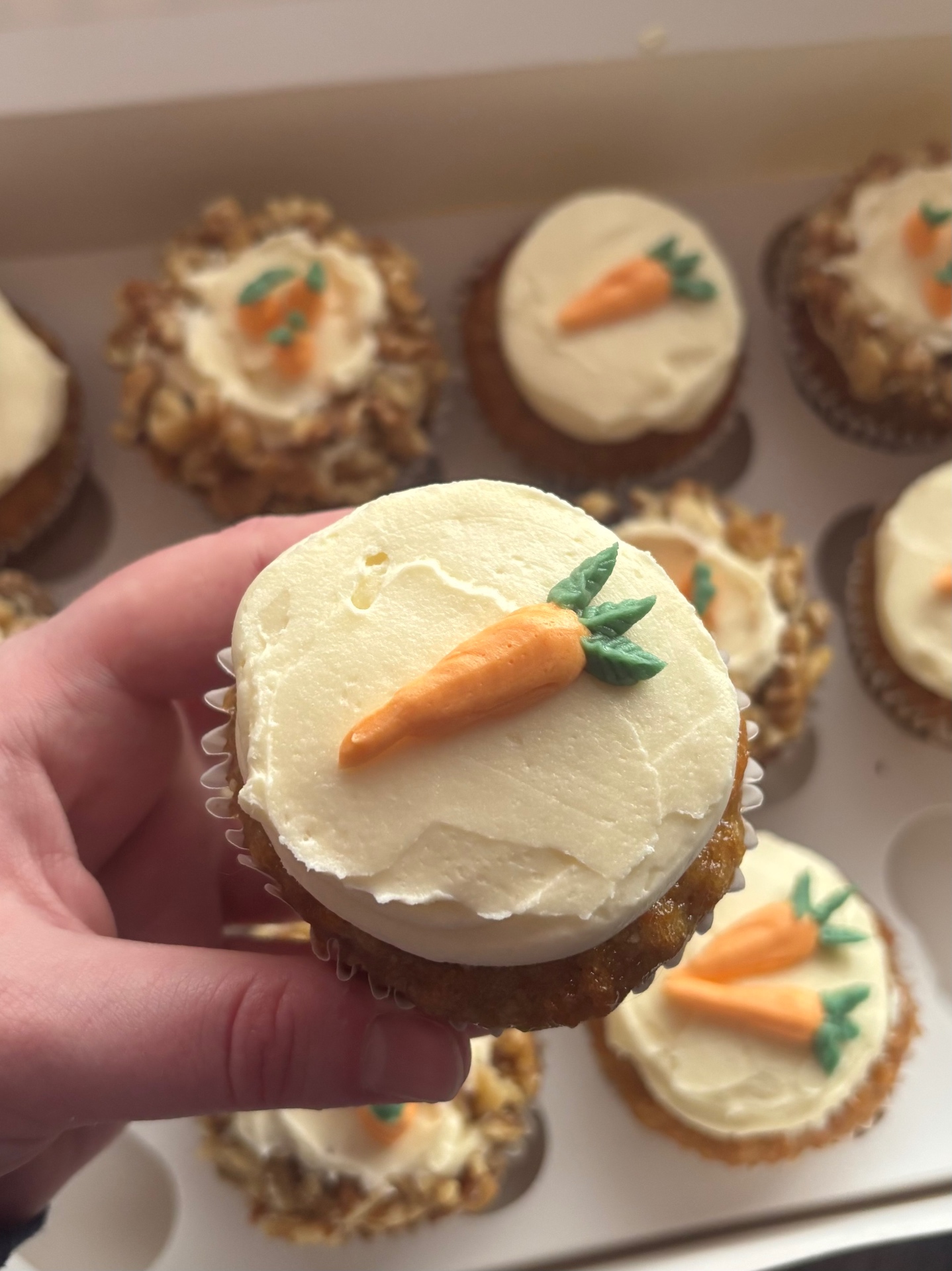 Carrot cake cupcakes with cream cheese frosting and piped carrot decorations